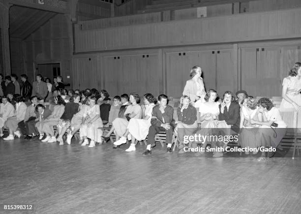 Young men and women sit awkwardly together on chairs beside the dance floor, during a high school dance in the gymnasium at Monterey Union High...