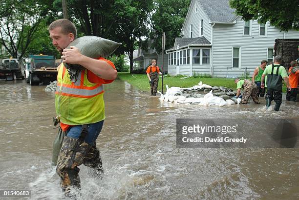City workers use sandbags to fight rising floodwaters from sewers on June 12, 2008 in Cedar Rapids, Iowa. Much of the city has been evacuated as the...