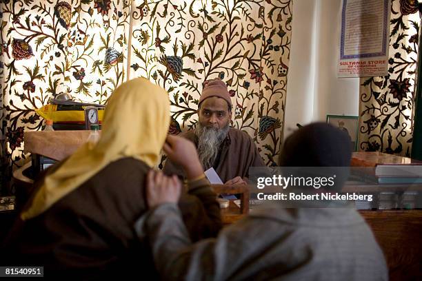 Kashmiri woman, Hameeda Nazir, 32 years, claiming she suffers from anxiety and high blood pressure, meets with a faith healer or peer, Mohammed Altaf...