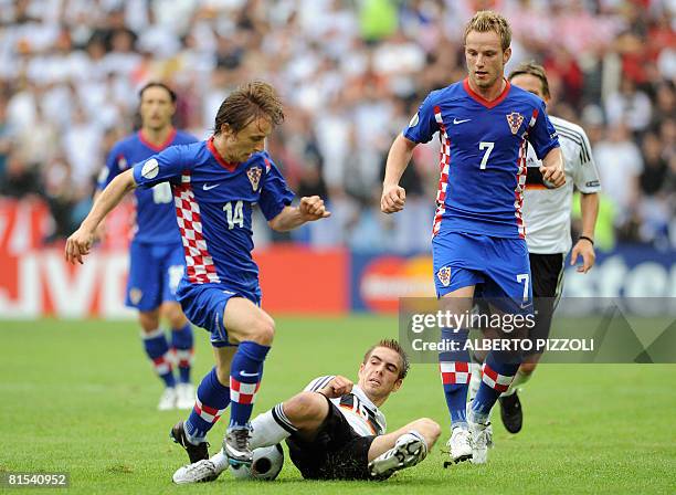 Croatian midfielder Luka Modric tackles German defender Philipp Lahm next to midfielder teammate Ivan Rakitic during their Euro 2008 Championships...