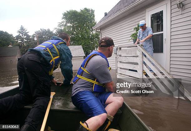 Justin Jensen of the Cedar Rapids Fire Department and Jake Siggins of the Lisbon, Iowa Fire Department prepare to resuce Tom Van Hoe from his flooded...