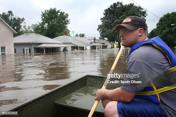 Jake Siggins of the Lisbon, Iowa Fire Department surveys homes searching for flood victims in need of rescue June 12, 2008 in Cedar Rapids, Iowa. The...