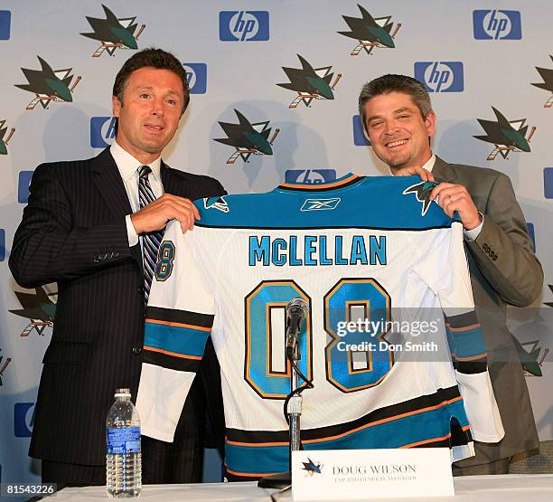 Todd McLellan, newly named Head Coach of the San Jose Sharks, receives his Sharks jersey from General Manager Doug Wilson during the press conference...