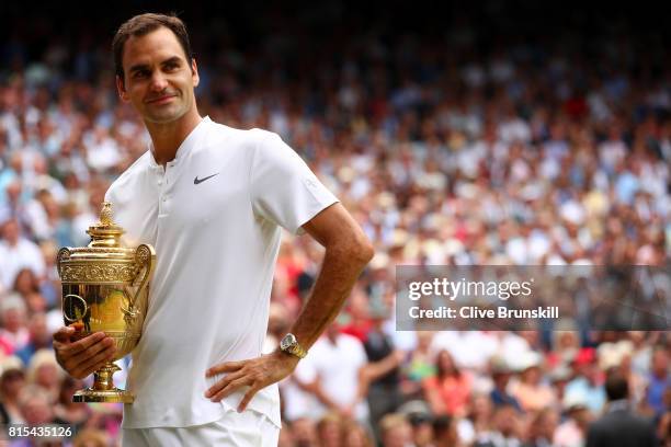 Roger Federer of Switzerland celebrates victory with the trophy after the Gentlemen's Singles final against Marin Cilic of Croatia on day thirteen of...