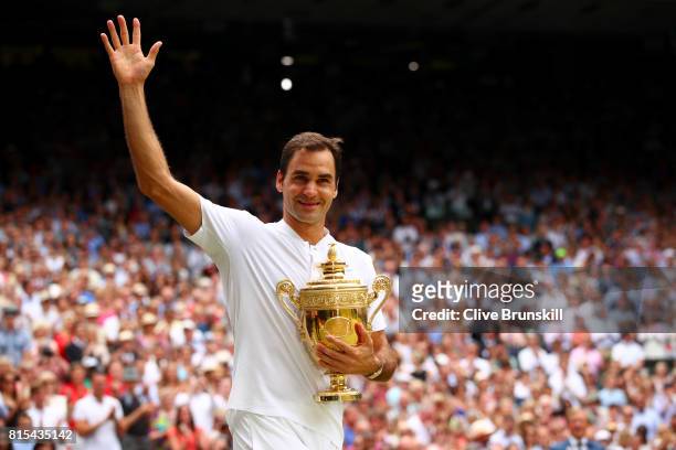 Roger Federer of Switzerland celebrates victory with the trophy after the Gentlemen's Singles final against Marin Cilic of Croatia on day thirteen of...