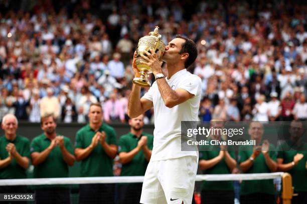 Roger Federer of Switzerland kisses the trophy as he celebrates victory after the Gentlemen's Singles final against Marin Cilic of Croatia on day...