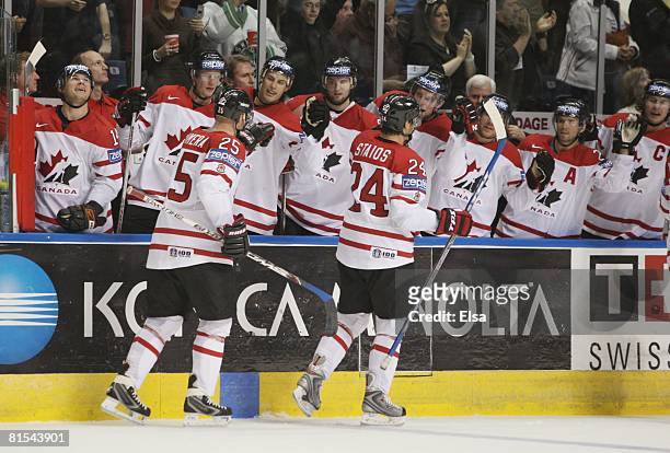 Steve Staios and Jason Chimera of Canada celebrate with teammates as they skate by the bench against Sweden during the Semifinal round of the...
