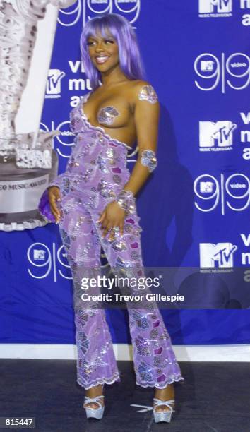 Musician Lil'' Kim poses for photographers backstage at the MTV Video Music Awards in New York City on September 9, 1999.