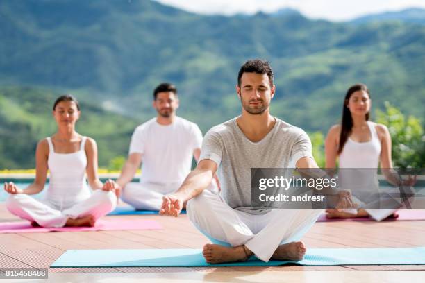 gruppe von menschen, die meditieren in einem yoga-kurs - yoga group stock-fotos und bilder