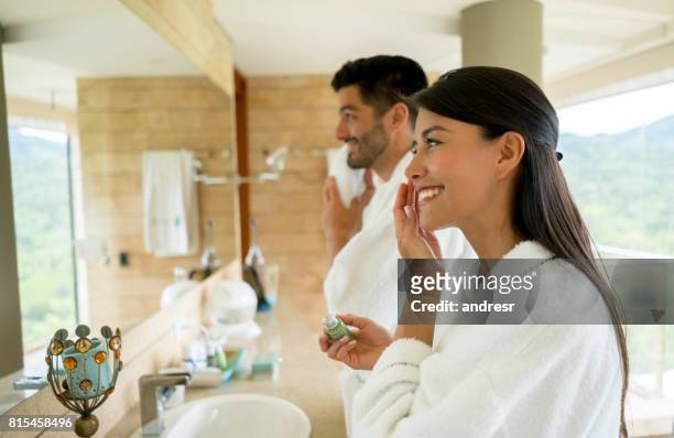 loving couple in the bathroom getting ready in the morning - man skin care stock pictures, royalty-free photos & images