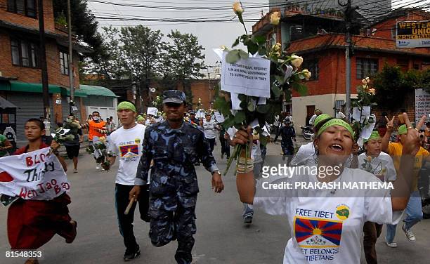 Pro-Tibetan activists hold bunches of white flowers while demonstrating in front of United Nations Headquarters in Nepal, in Kathmandu June 13, 2008....