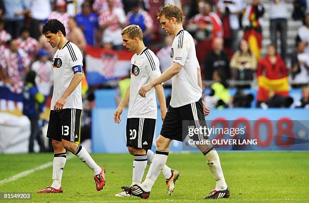 Germany's midfielder and captain Michael Ballack, striker Lukas Podolski and defender Per Mertesacker leave the pitch after the Euro 2008...