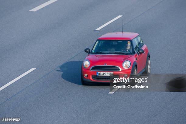 red mini alla guida su un'autostrada a più corsie in germania - multiple lane highway foto e immagini stock