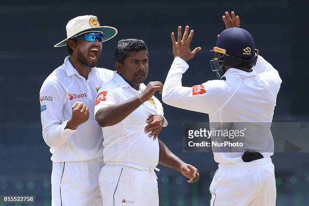 Sri Lanka's Rangana Herath and capatain Dinesh Chandimal celebrate taking the wicket of Zimbabwe's Hamilton Masakadza during the third day's play of...