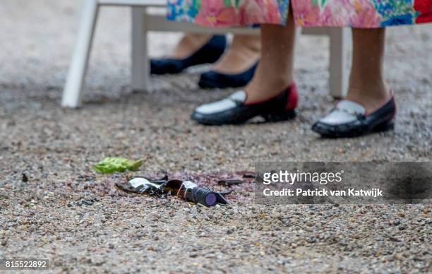 Queen Margrethe of Denmark drops a bottle of wine after she got is as a gift during the Ringsted horse ceremony at Grasten Slot during their summer...