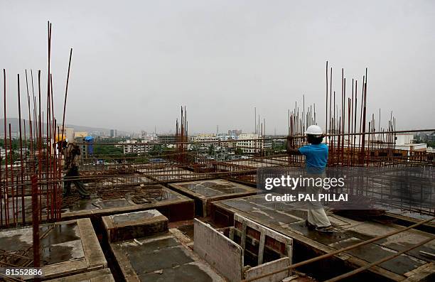 Indian labourers work at a construction site in Mumbai on June 13, 2008. India's inflation hit its highest level in over seven years, stoking...