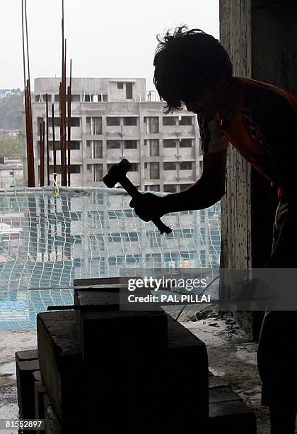 An Indian labourer works at a construction site in Mumbai on June 13, 2008. India's inflation hit its highest level in over seven years, stoking...