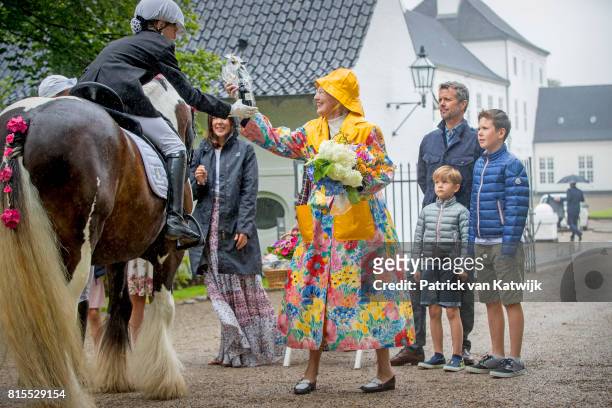 Queen Margrethe of Denmark drops a bottle of wine after she got is as a gift during the Ringsted horse ceremony at Grasten Slot during their summer...