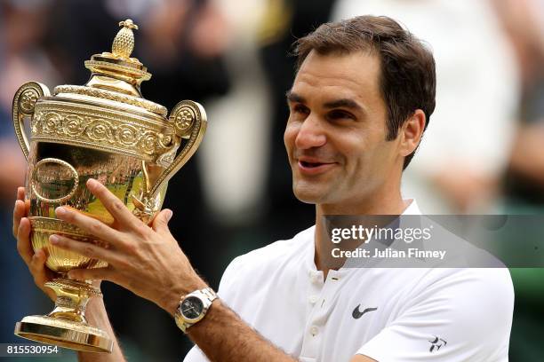 Roger Federer of Switzerland celebrates victory with the trophy after the Gentlemen's Singles final against Marin Cilic of Croatia on day thirteen of...