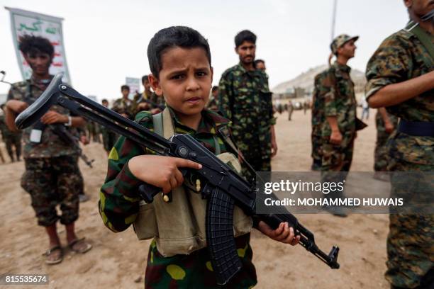 Yemeni boy poses with a Kalashnikov assault rifle during a gathering of newly-recruited Huthi fighters in the capital Sanaa, to mobilize more...