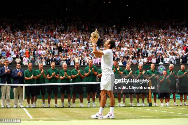 Roger Federer of Switzerland celebrates victory with the trophy after the Gentlemen's Singles final against Marin Cilic of Croatia on day thirteen of...