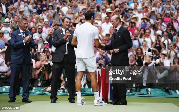 Roger Federer of Switzerland is presented with the trophy by The Duke of Kent as LTA President Martin Corrie and AELTC Chairman Philip Brook look on...