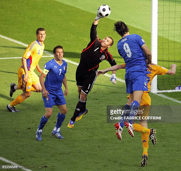 Romanian goalkeeper Bogdan Lobont catches the ball headed by Italian forward Luca Toni next to Romanian defender Gabriel Tamas and Italian forward...