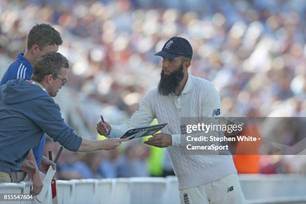 England's Moeen Ali signs autographs during a break in play at Trent Bridge on July 16, 2017 in Nottingham, England.