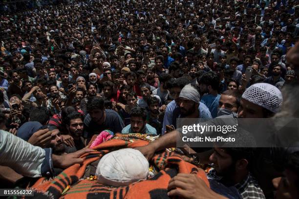 Kashmiri villagers touch the body of a local rebel Parvaiz Mir during his funeral procession, Sunday, July 16 in Pohoo village 38 kilometres south of...