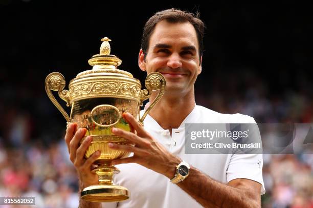 Roger Federer of Switzerland celebrates victory with the trophy after the Gentlemen's Singles final against Marin Cilic of Croatia on day thirteen of...