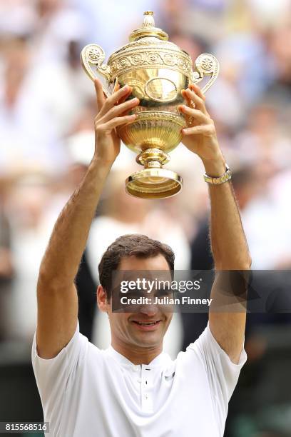 Roger Federer of Switzerland celebrates victory with the trophy after the Gentlemen's Singles final against Marin Cilic of Croatia on day thirteen of...