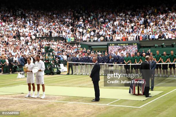 Roger Federer of Switzerland celebrates victory with the trophy alongside runner-up Marin Cilic of Croatia after the Gentlemen's Singles final on day...