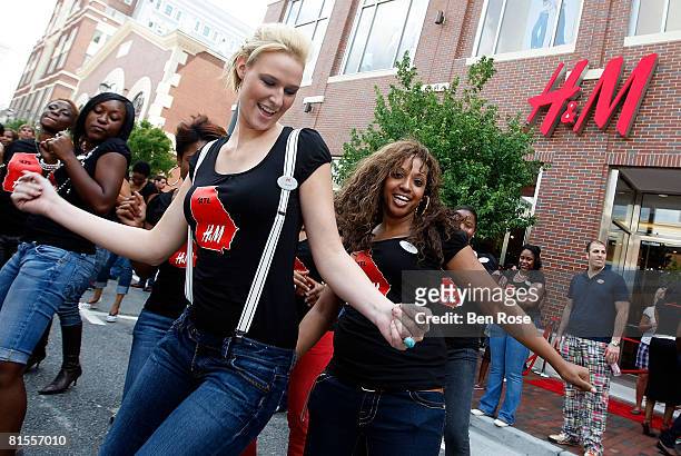Store employees hold an impromptu street party before the opening of their store at Atlantic Station on June 13, 2008 in Atlanta, Georgia.