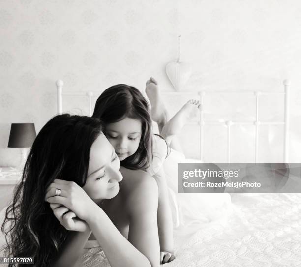 mother and daughter in bed - meisje stock-fotos und bilder