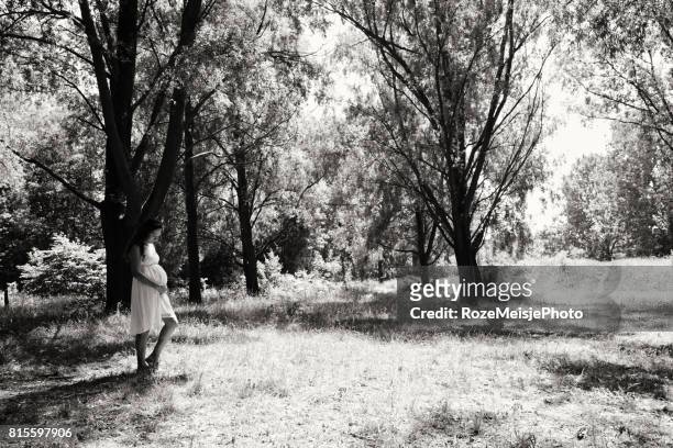 pregnant woman in the forest - meisje stock-fotos und bilder