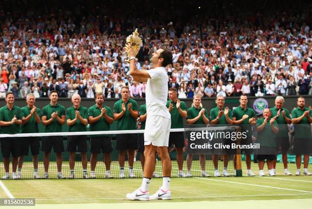 Roger Federer of Switzerland celebrates victory with the trophy after the Gentlemen's Singles final against Marin Cilic of Croatia on day thirteen of...