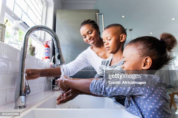 familie wassen hun handen samen. - fontein stockfoto's en -beelden