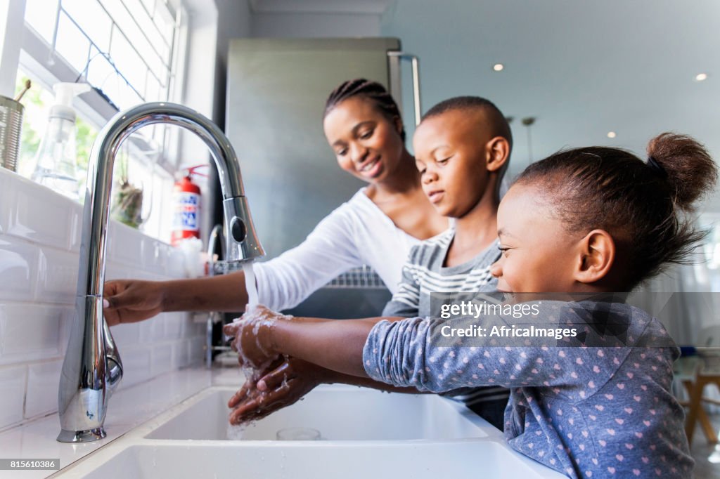 Family washing their hands together.