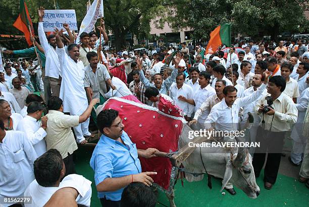 Activists from India's main opposition Bharatiya Janata Party and farmers ride on a bullock cart as they shout anti-Congress-led UPA government...