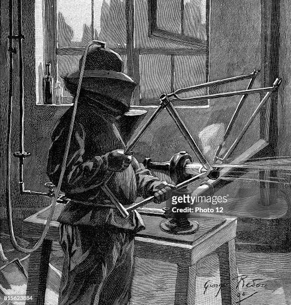 Sandblasting the joints of a bicycle frame; operator wears helmet with breathing tube and a protective tunic: France. Wood engraving Paris 1896.