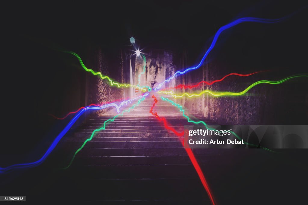 Colorful light trails with nice vanishing point and motion at night in the stairs of the old medieval streets of the Girona city.