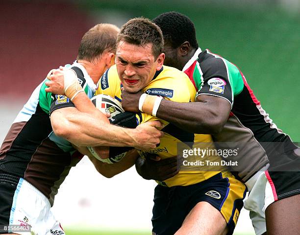 Kevin Sinfield of Leeds Rhinos is tackled by Scott Hill and Mike Worrincy of Harlequins RL during the engage Super League match between Harlequins RL...