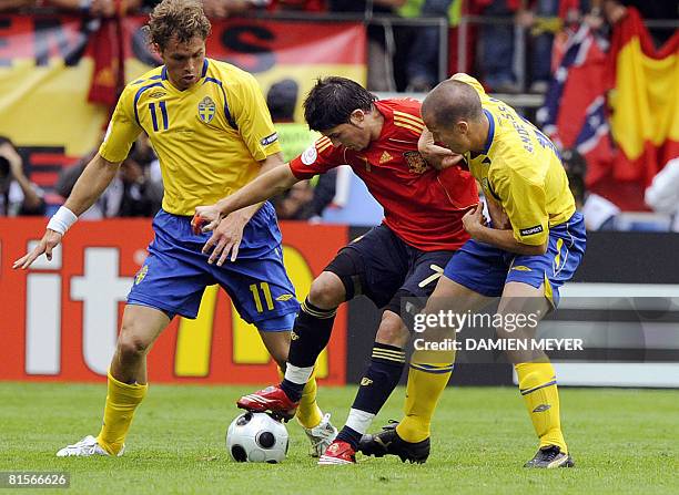 Spanish forward David Villa fights for the ball with Swedish forward Johan Elmander and Swedish midfielder Daniel Andersson during the Euro 2008...