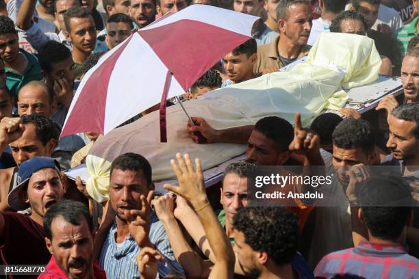 People carry the body of Ali El Gizavi who died during clashes breaking out after security forces destroyed some houses claiming that they are...