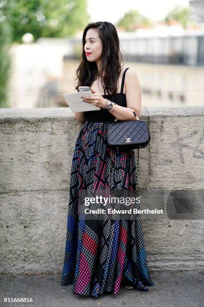 Guest wears a black tank top, a black leather chanel bag, a colored ruffle skirt, outside the launch party for Chanel's new perfume 'Gabrielle',...