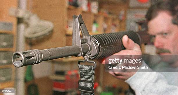 Wright Gibb looks down the barrel of an AR-15 assault rifle after cleaning it March 8, 2001 at his residence in Westminster, Co. Gibb bought a...