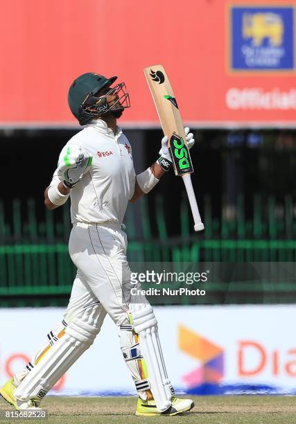 Zimbabwe's Sikandar Raza looks up to the sky and reacts after scoring fifty runs during the third day's play of the only test cricket match between...