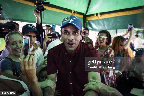 Henrique Capriles, opposition leader and governor of the State of Miranda, greets voters as he arrives at a polling station to vote during a symbolic...