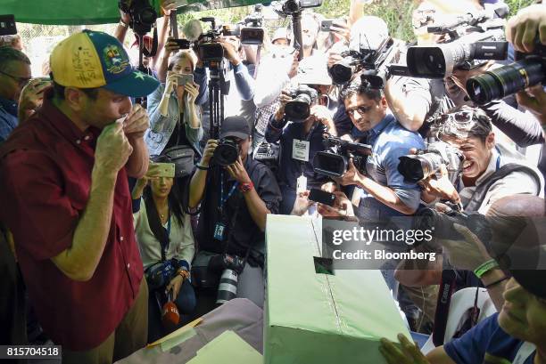 Henrique Capriles, opposition leader and governor of the State of Miranda, kisses a ballot before casting it at a polling station during a symbolic...