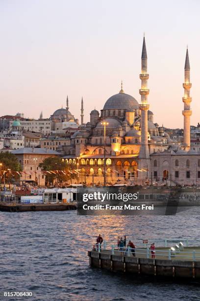 people on a pier of a pillar of galata bridge, in the background yeni-valide mosque and nuruosmaniye mosque, sultanahmet district - istanbul photos et images de collection